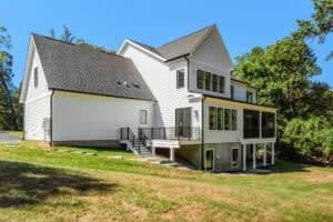 Modern white new construction house with black trim and screened porch, located in Kingston Royce community.